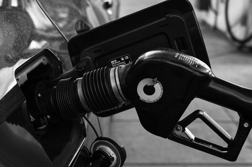 gas-pump-nozzle-in-the-cars-filler-neck-21811094 Detailed close-up of a refueling nozzle in monochrome at a gas station, highlighting the petrol filling process.